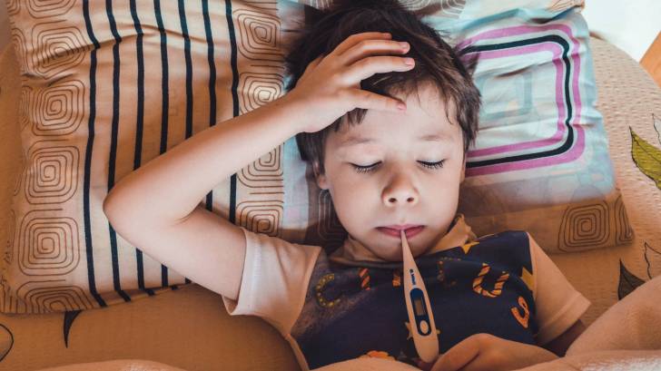 young boy in bed sick with a cold